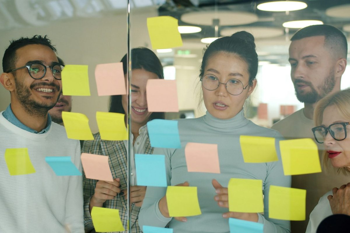 Small team planning with sticky notes on a glass wall